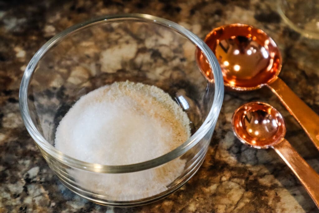 yeast and sugar in bowl with measuring spoons